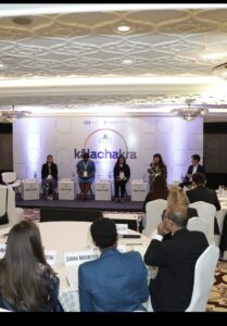 A panel of five speakers sits on stage at the Kalachakra event.